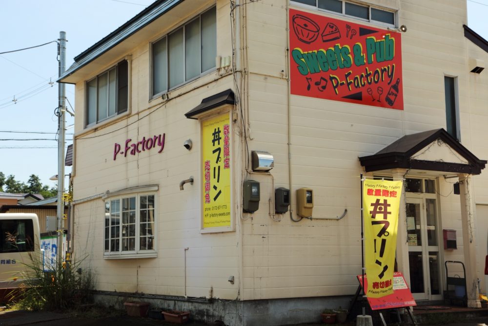 赤い看板と「丼プリン」の旗が目印
