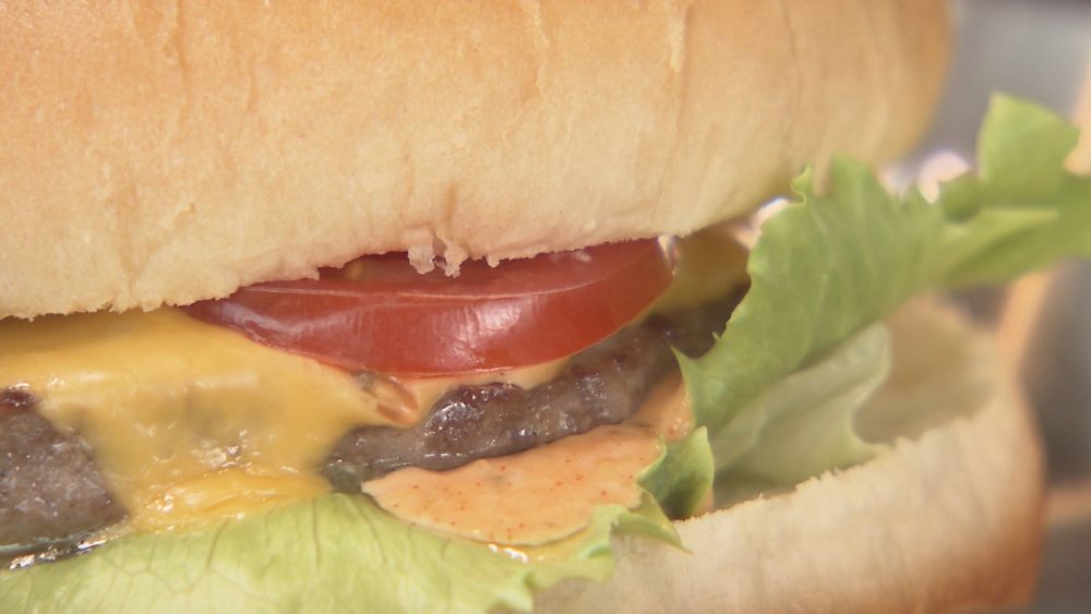 牛肉のパティにレタス、トマト、チーズをサンド